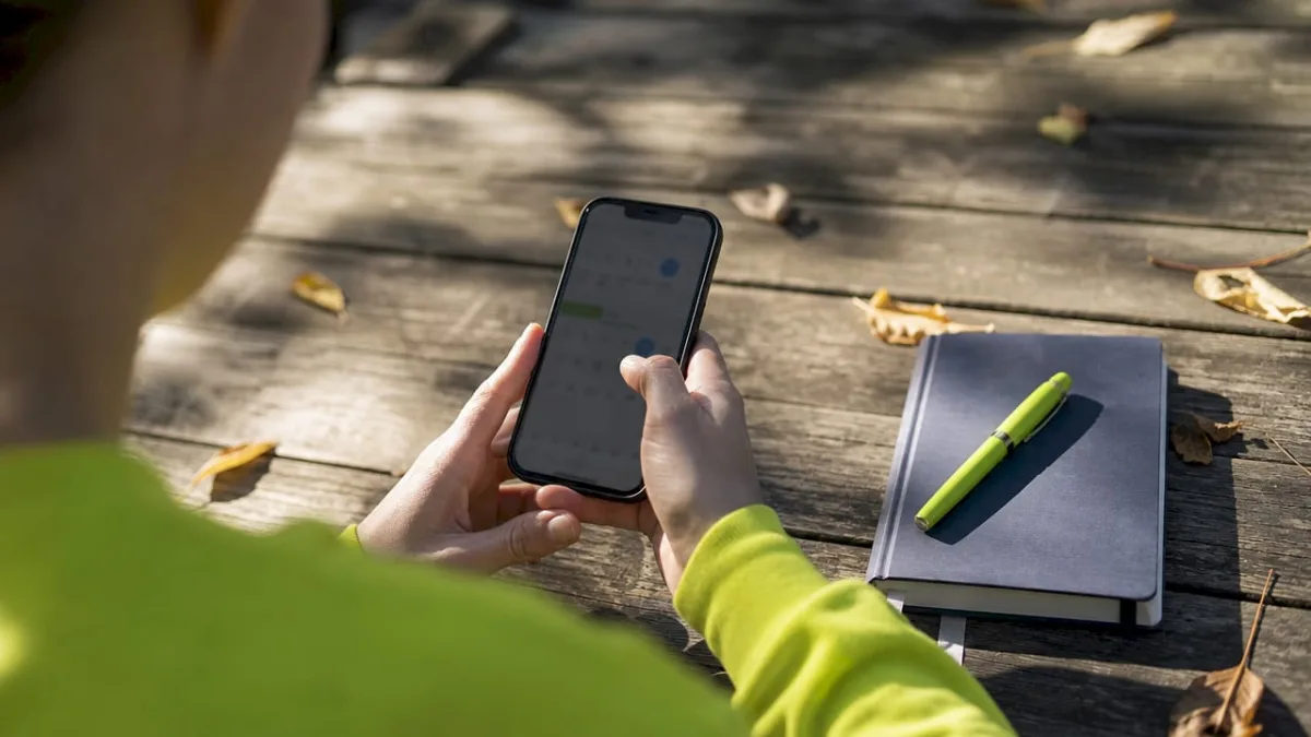 Hands setting biweekly website maintenance reminder on phone